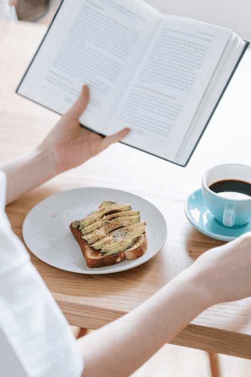 person enjoying healthy food and coffee while reading a book  