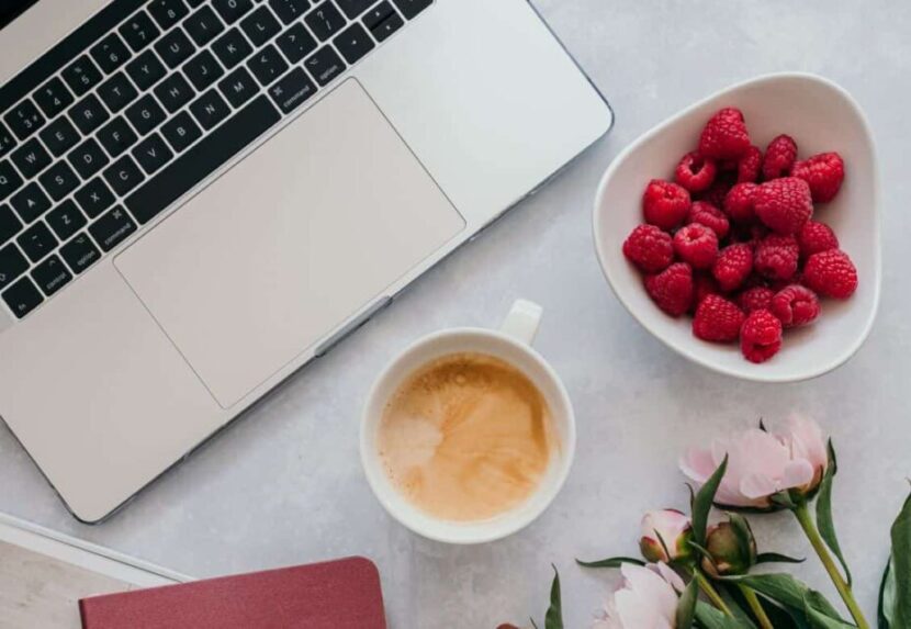 A picture of an open laptop with a white screen and silver keyboard with fruit and flowers #AltText #LaptopImage